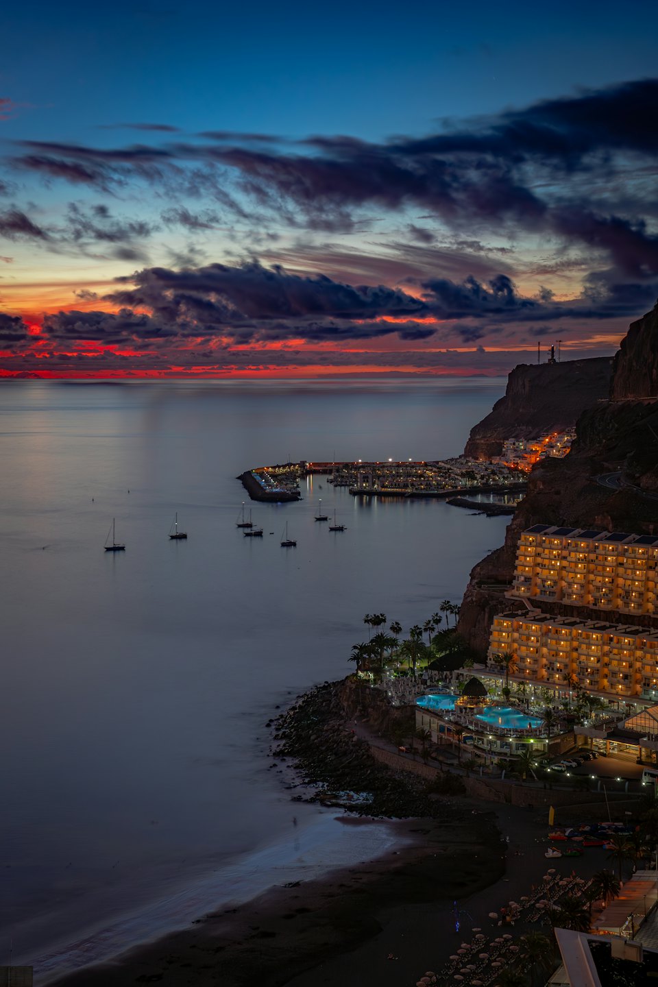 Località turistica costiera e marina illuminate al crepuscolo.