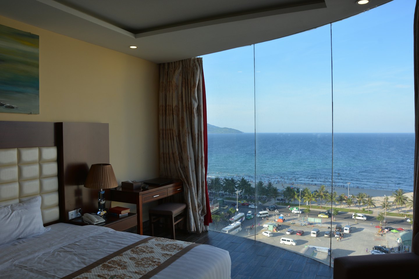 Camera d'albergo moderna con vista mare, scrivania e testiera trapuntata.