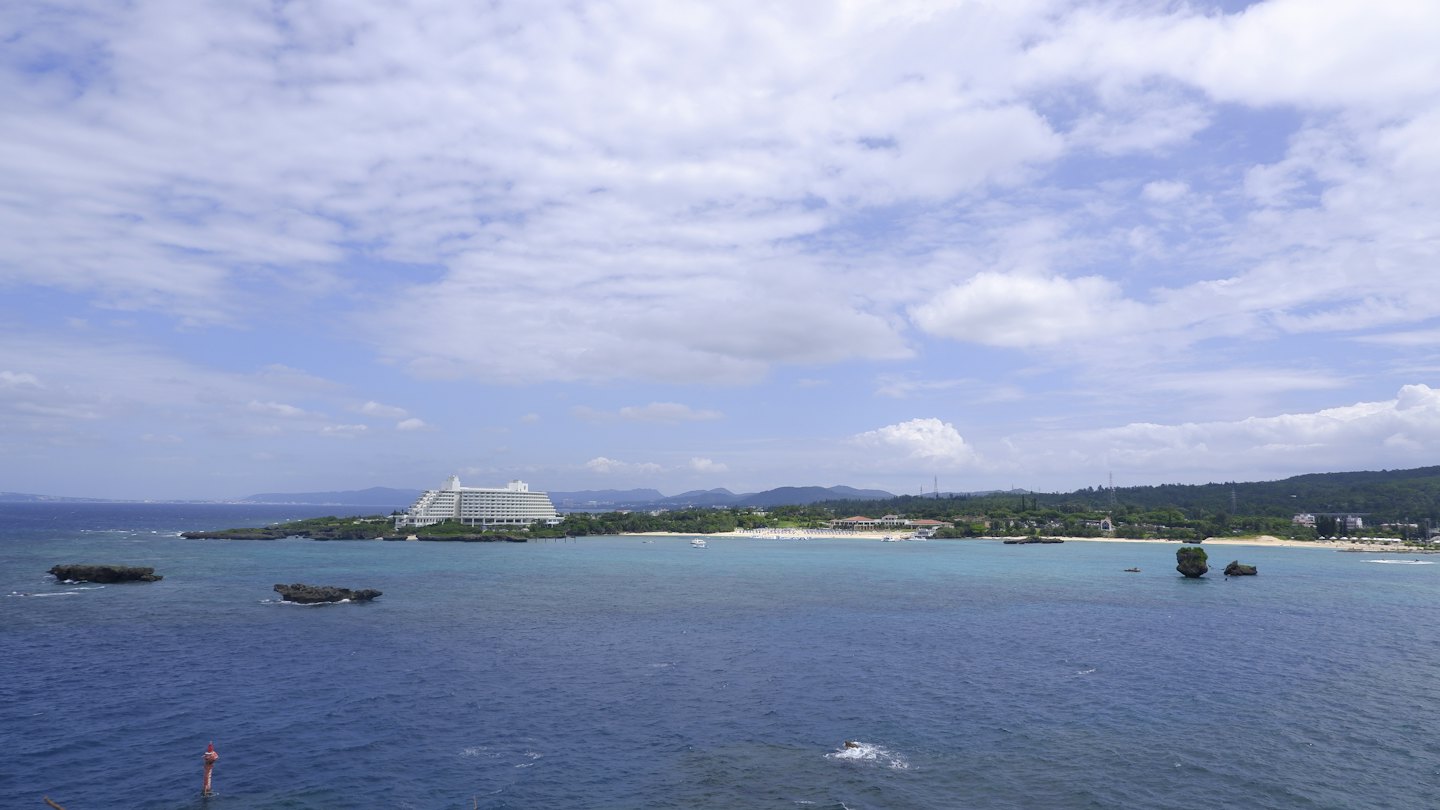 Moderno hotel bianco su una penisola verde affacciato sull'oceano.